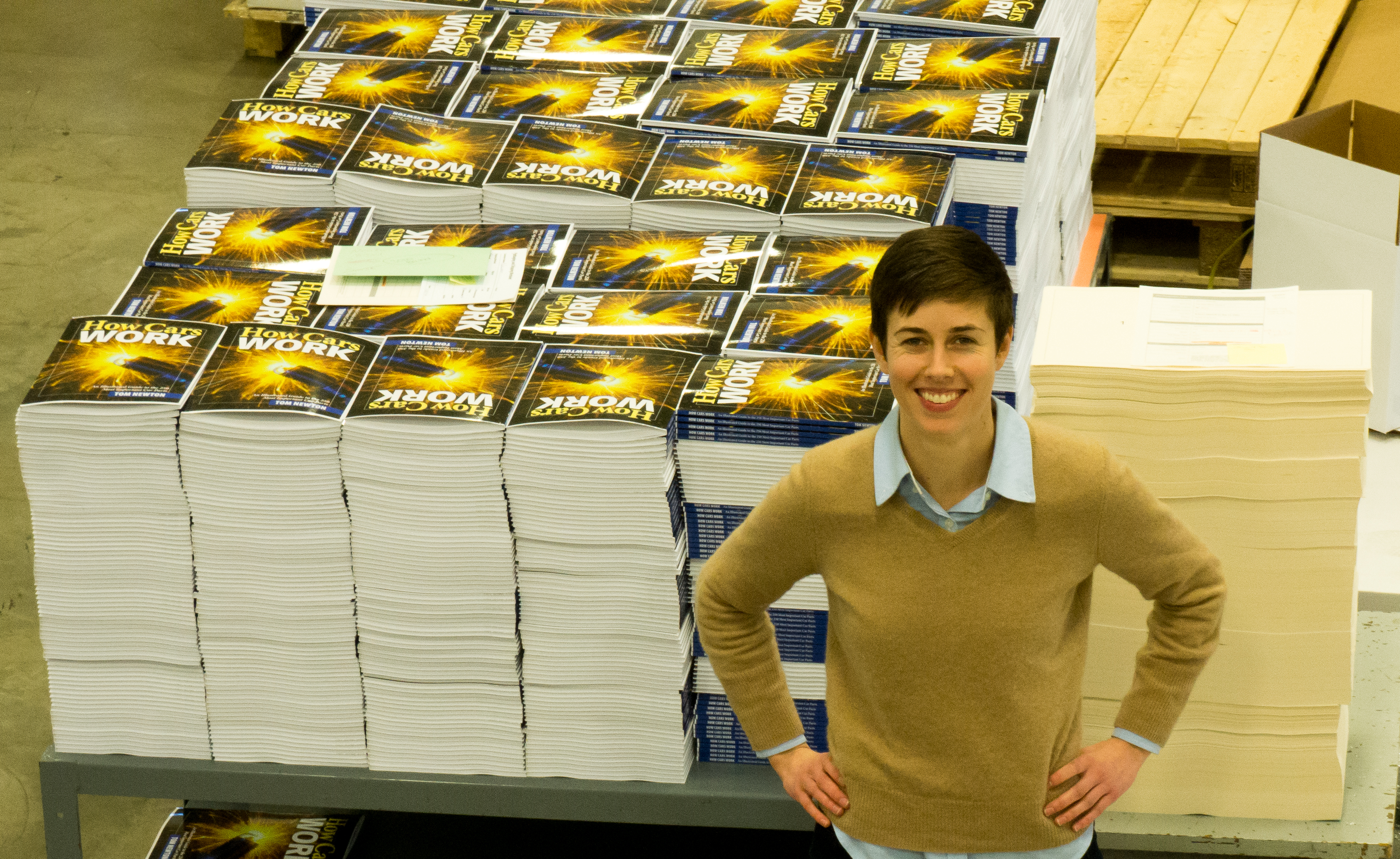 Alison standing with all the printed books Gorham Printing