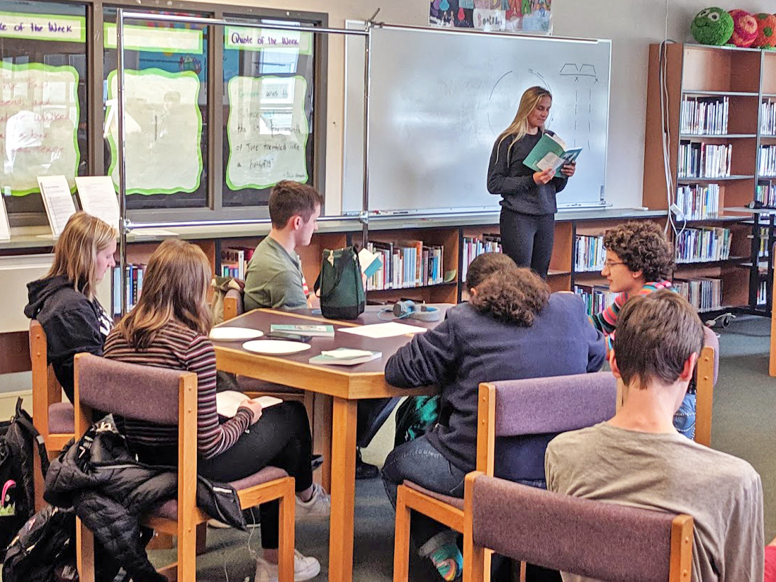 Olympia High School student reading the book in front of class